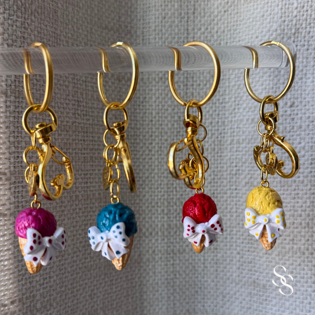 Four gold-accented keychains with colorful ice cream charms 