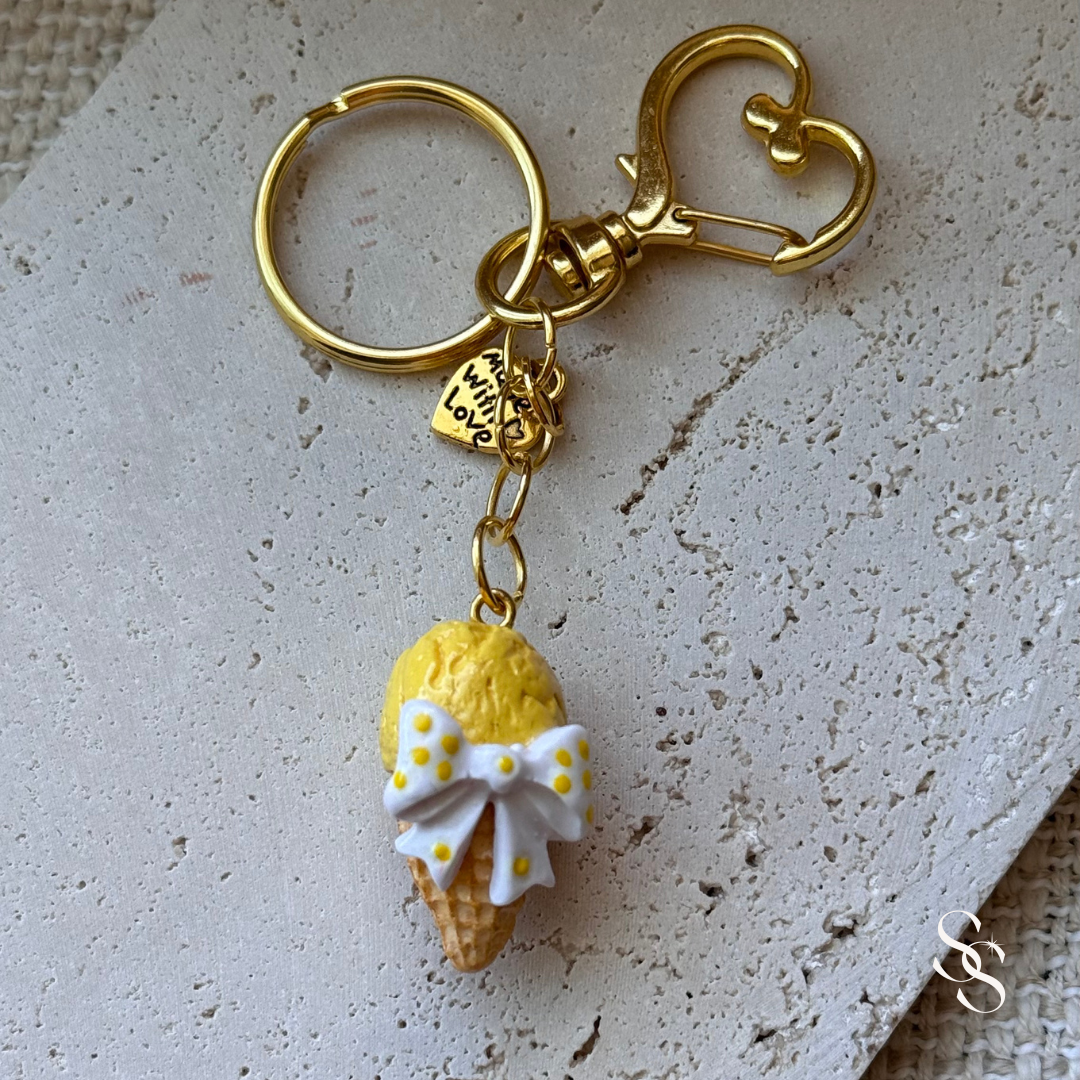 Keychain with a yellow ice cream cone charm on a textured surface