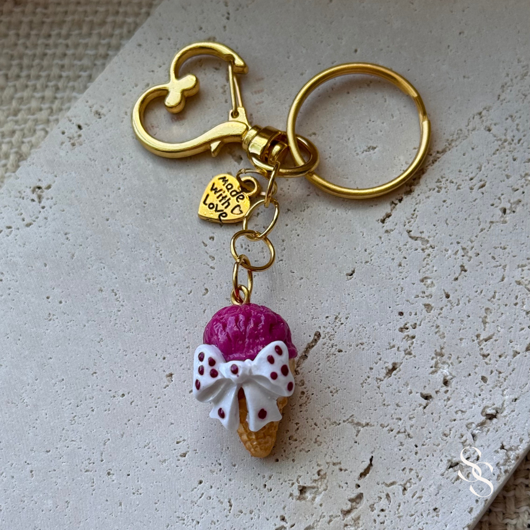 Keychain with ice cream cone charm and heart-shaped tag on a textured surface